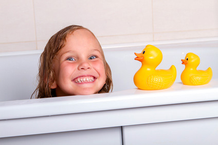 Kleines Mädchen in der Badewanne mit Quietscheenten