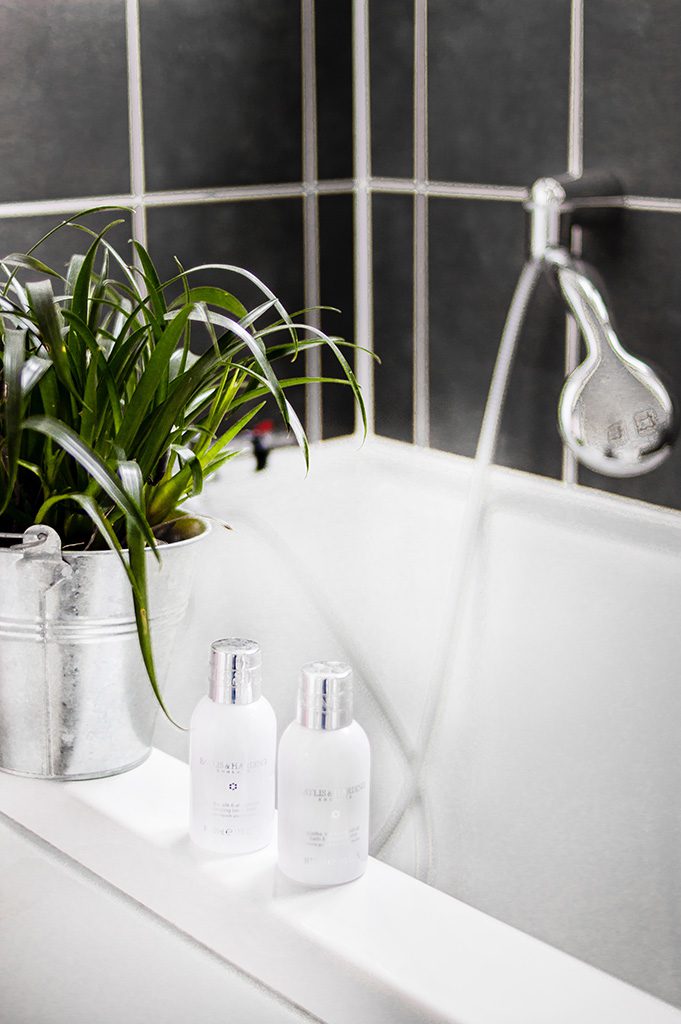 Shampoo und Pflegeprodukte griffbereit am Rand der Badewanne