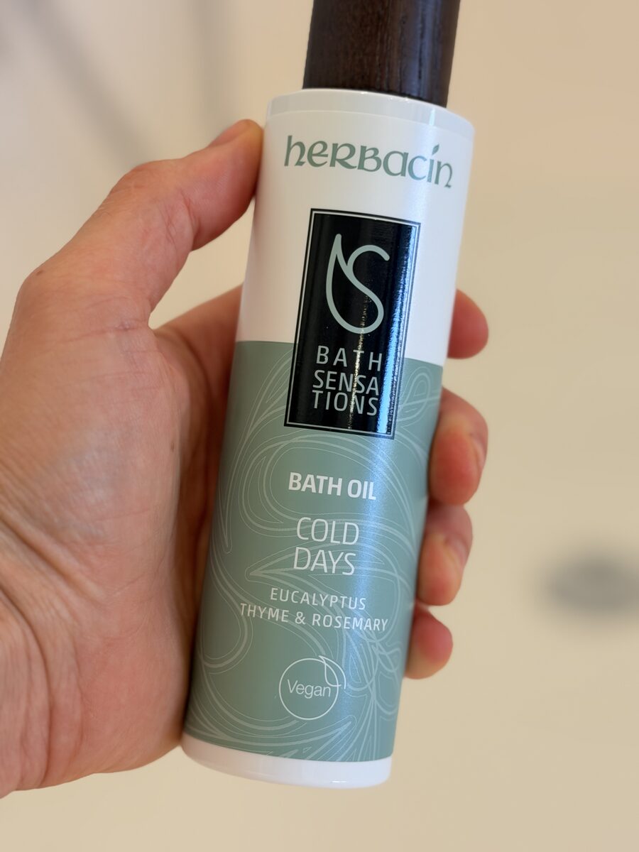 Herbacin Badeöl Cold Days Flasche in der Hand im Badezimmer